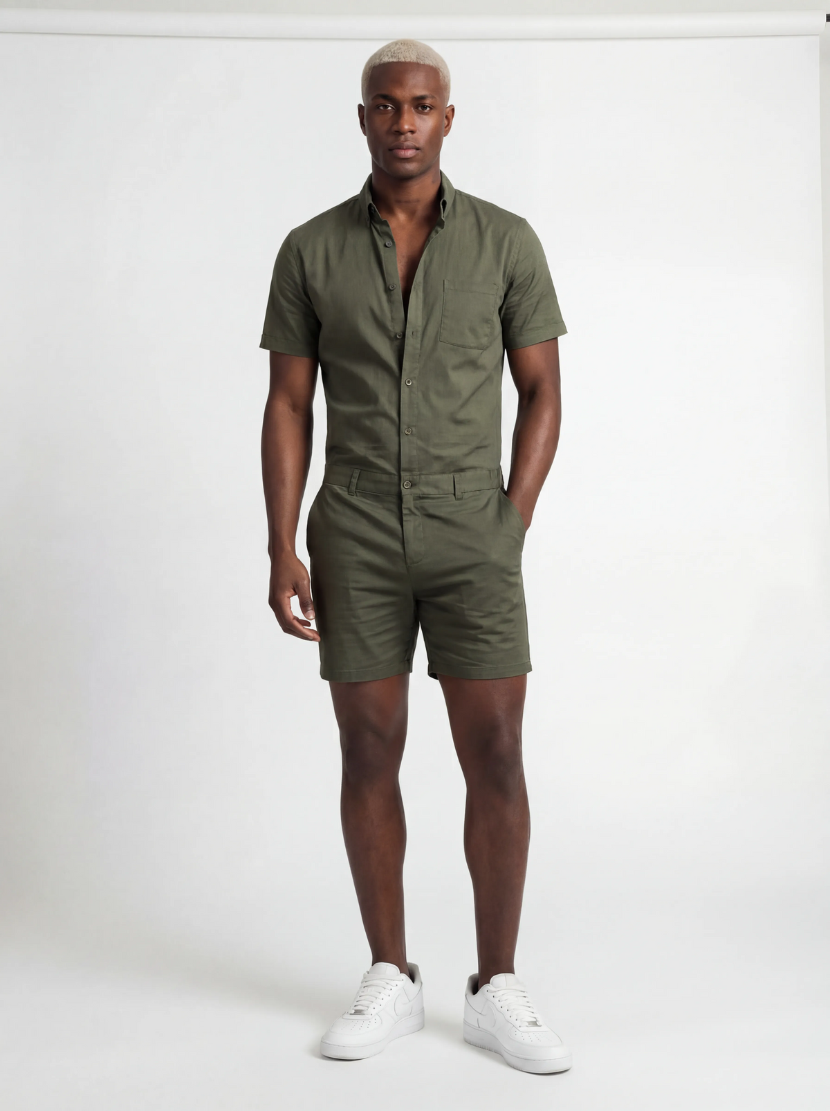 Man wearing a green romper with a white background